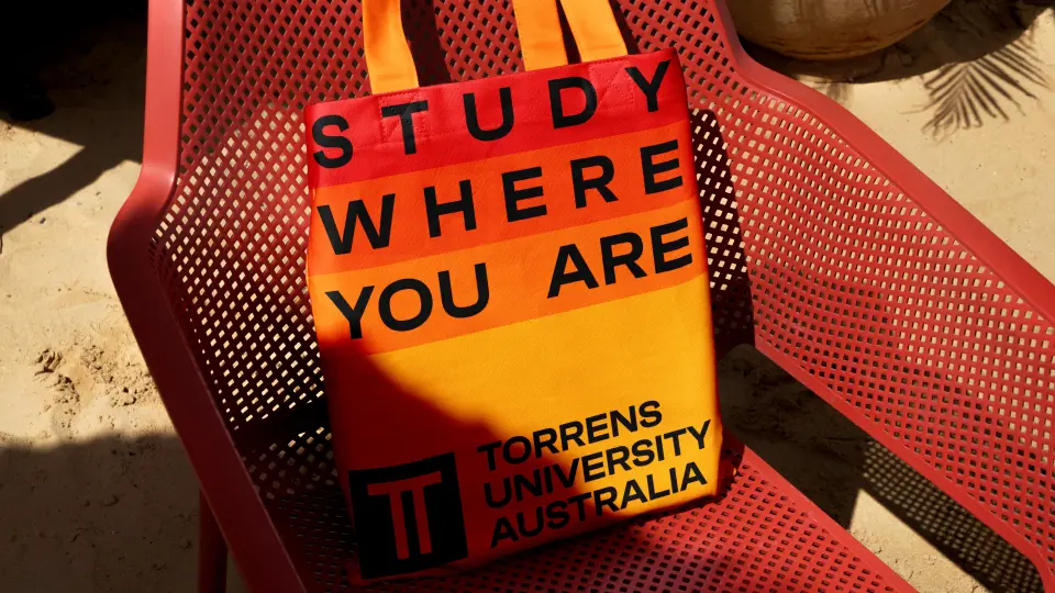 Hands holding a red sign reading “Study where you are”