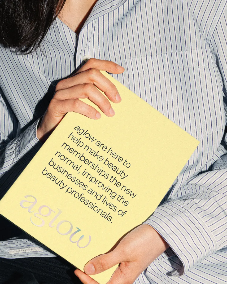 Person in a striped shirt holding a yellow aglow printed card