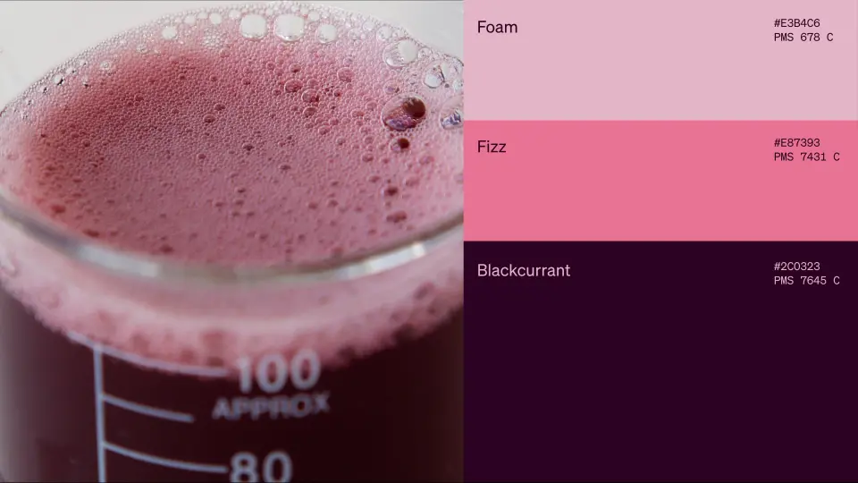 Glass beaker of pink Ārepa drink beside pink and purple colour swatches