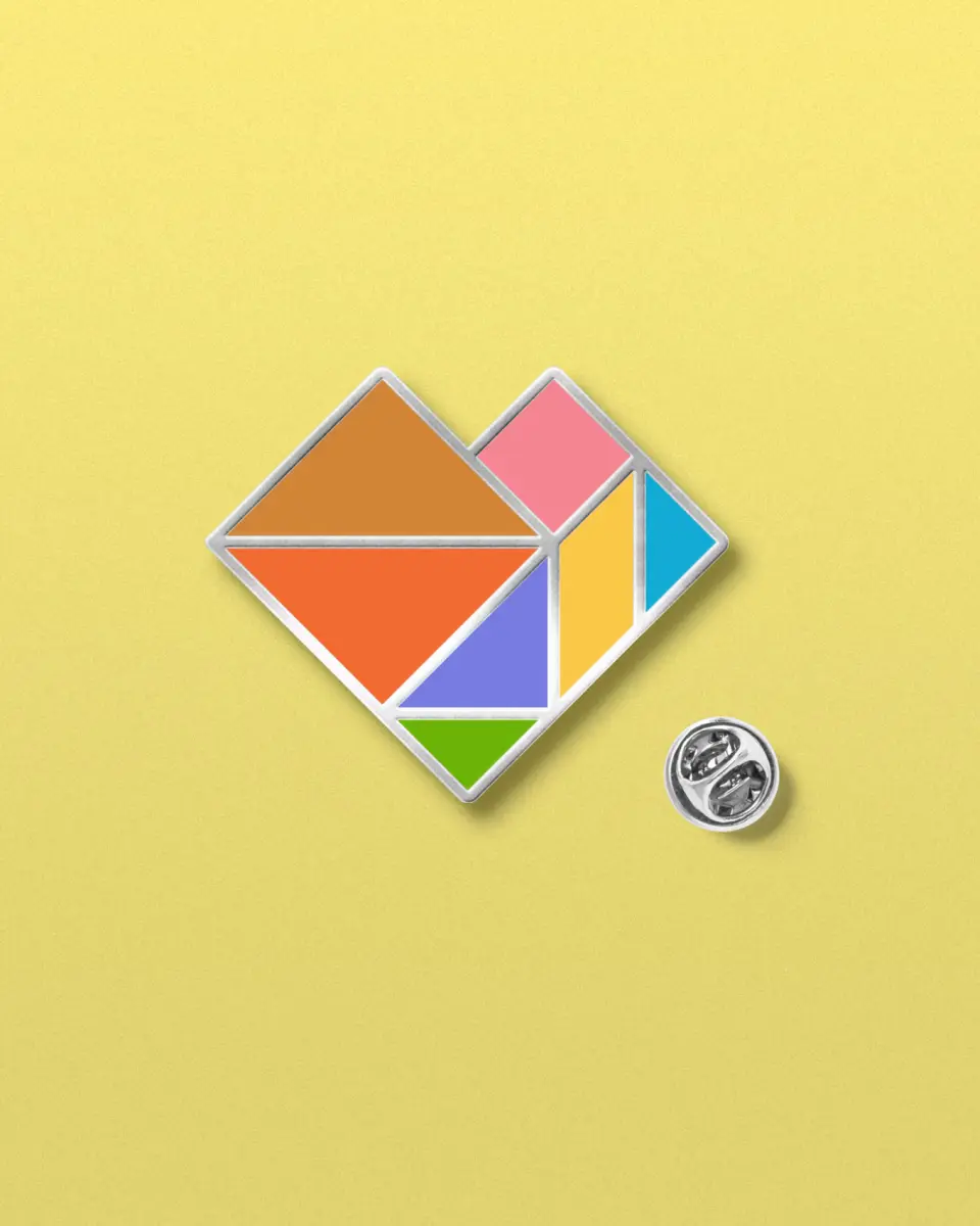 Pin badge with a colourful geometric heart on a yellow background