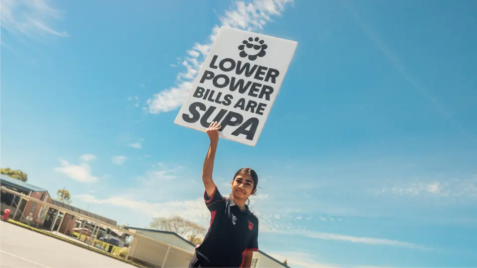 Person holding a sign aloft against a blue sky