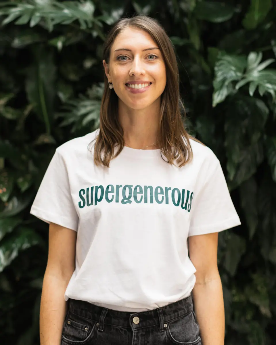 Smiling woman wearing a Supergenerous t-shirt outdoors