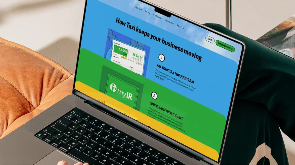 Laptop showing the Taxi website on a desk