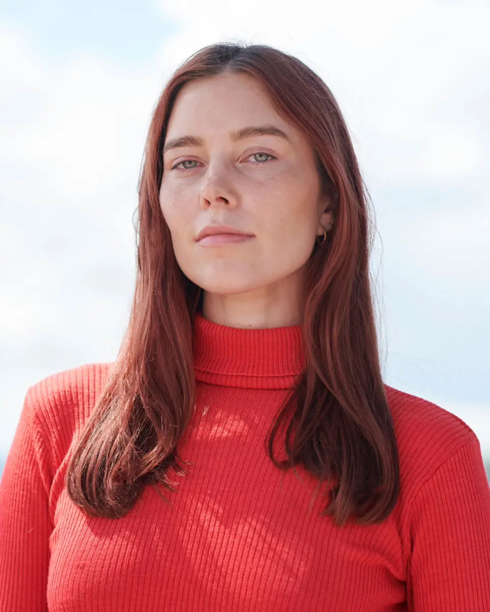 Portrait of a woman with long hair wearing a red top