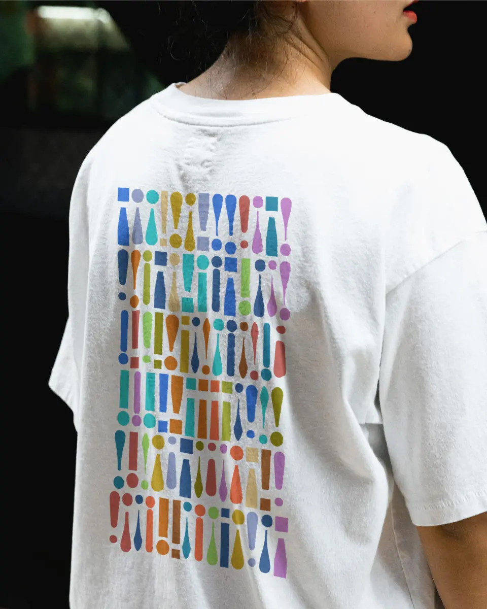 Person from behind wearing a white t-shirt with a colourful figure pattern