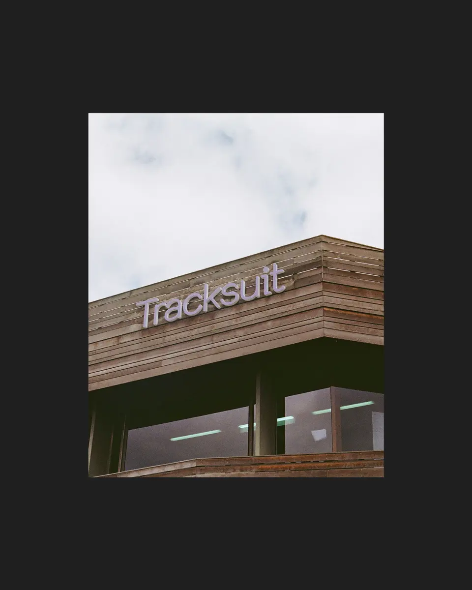 Tracksuit sign on a building exterior against a dark backdrop