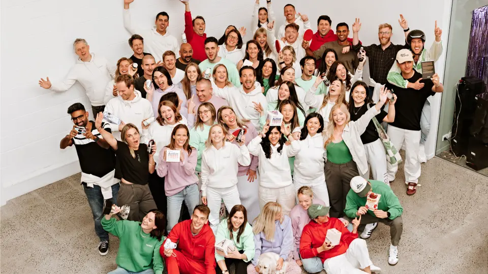 Large group of people in a studio, many in red and white