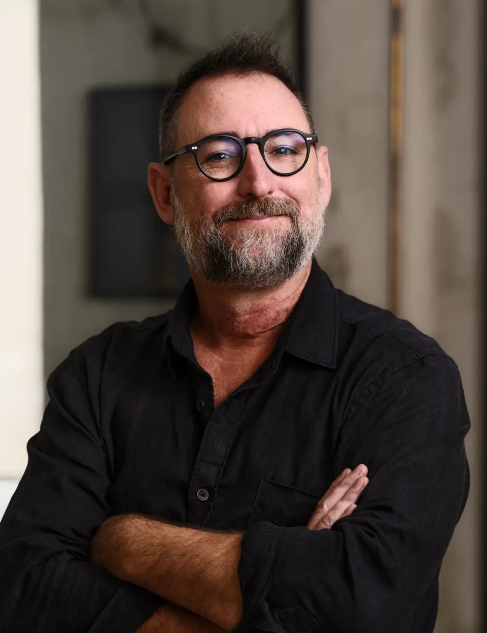 Portrait of James Hurman, bearded man in glasses with arms crossed