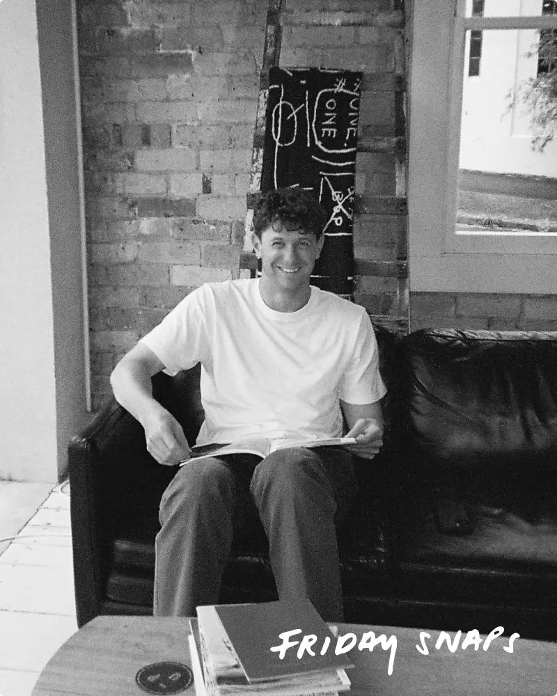 Black and white photo of a man sitting on a sofa